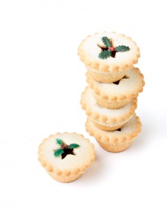 Tower of sugared Sweet Mince Pies against plain white background.
